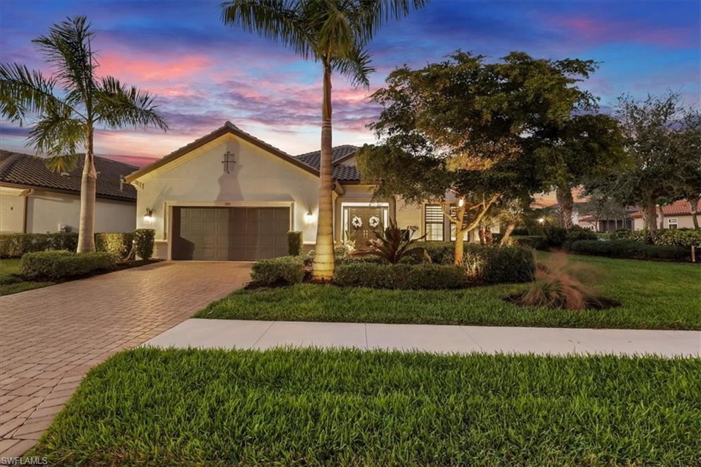 Image 1: Mediterranean / spanish-style home with a lawn, stucco siding, decorative driveway, a garage, and a tiled roof