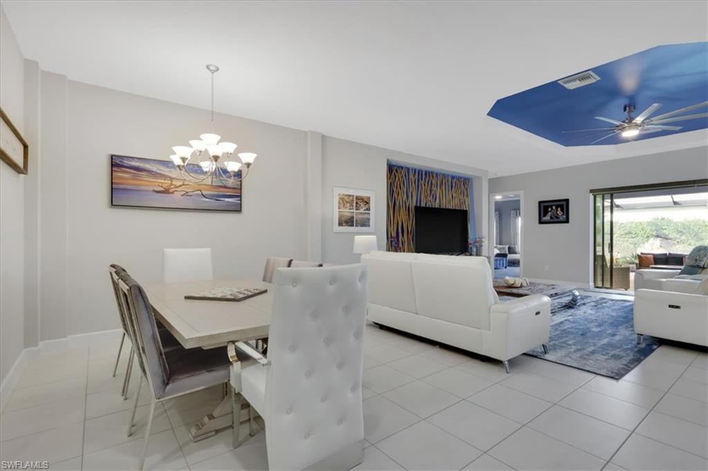 Image 3: Dining area featuring light tile patterned floors and a chandelier
