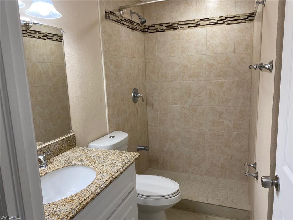 Image 3: Bathroom with a textured wall, vanity, and a shower stall