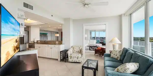 Image 3: Living area featuring a ceiling fan, light tile patterned floors, and a tray ceiling