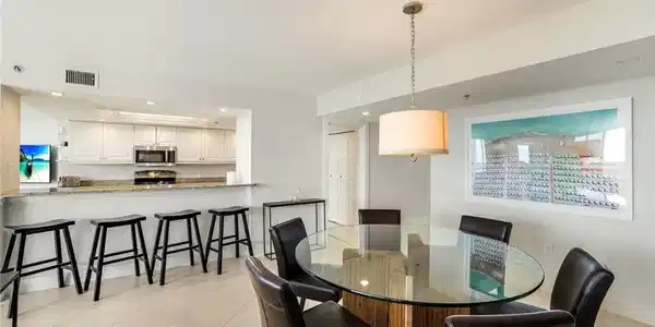 Image 4: Dining space with light tile patterned floors and recessed lighting