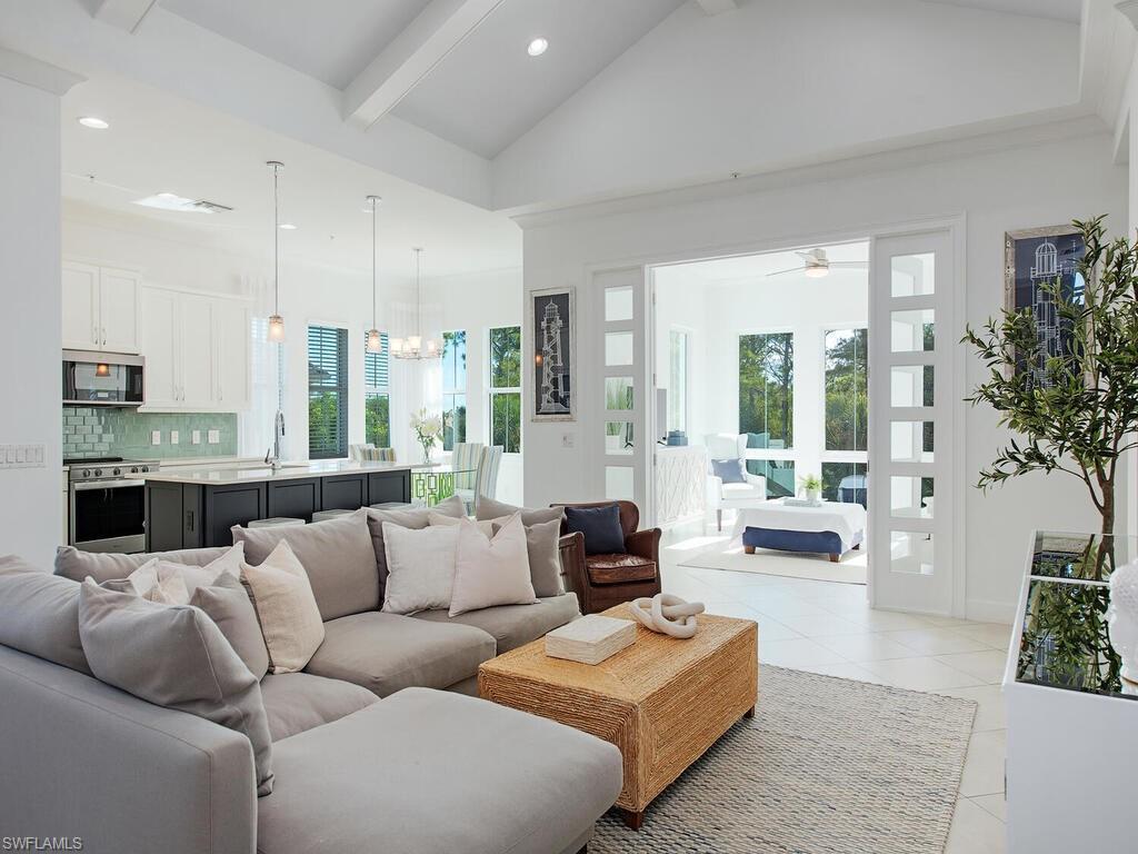 Image 4: Living room featuring a chandelier, beam ceiling, healthy amount of natural light, recessed lighting, and light tile patterned floors