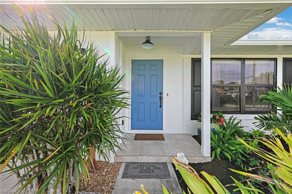 Image 2: Property entrance with covered porch and stucco siding