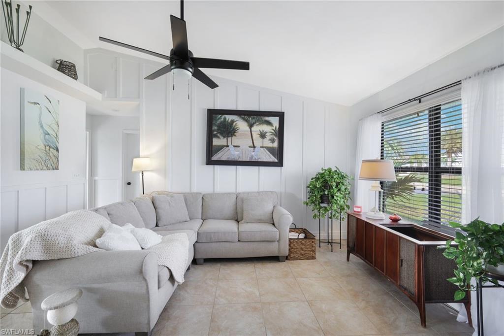 Image 4: Living area featuring a decorative wall, lofted ceiling, and a ceiling fan