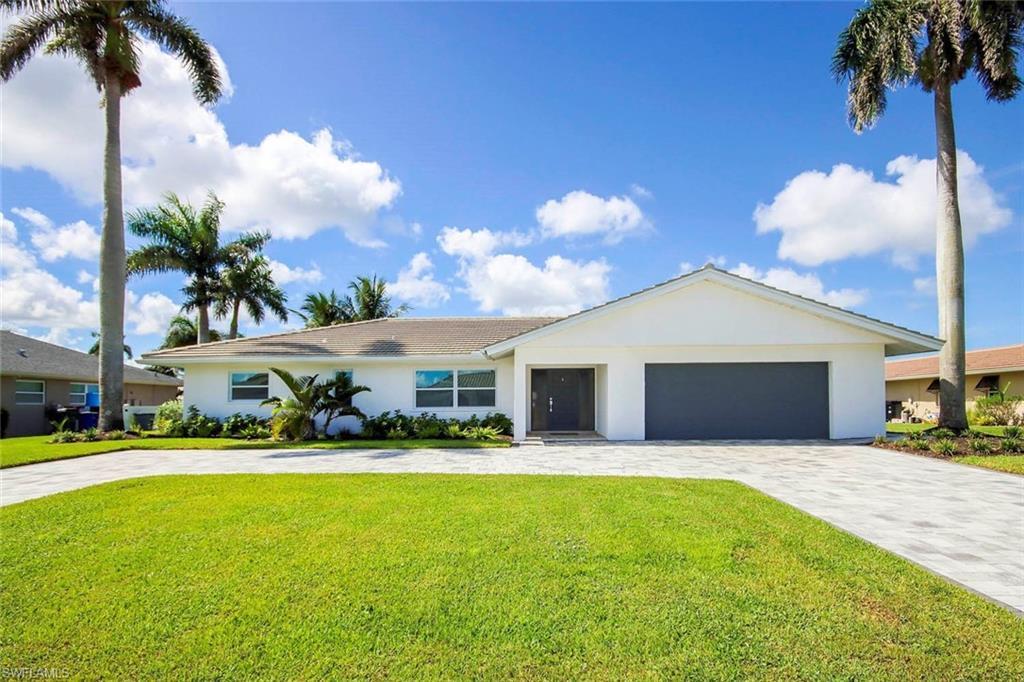 Image 1: Ranch-style home featuring decorative driveway, stucco siding, a front yard, and an attached garage