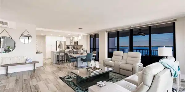 Image 3: Living room featuring ceiling fan, a water view, a wall of windows, and light hardwood / wood-style flooring