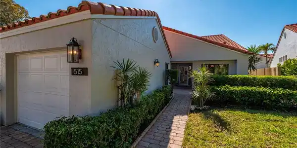 Image 2: View of front of home with a tile roof, stucco siding, and a garage