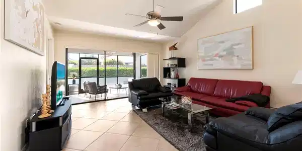 Image 4: Living area featuring a ceiling fan, light tile patterned floors, and lofted ceiling