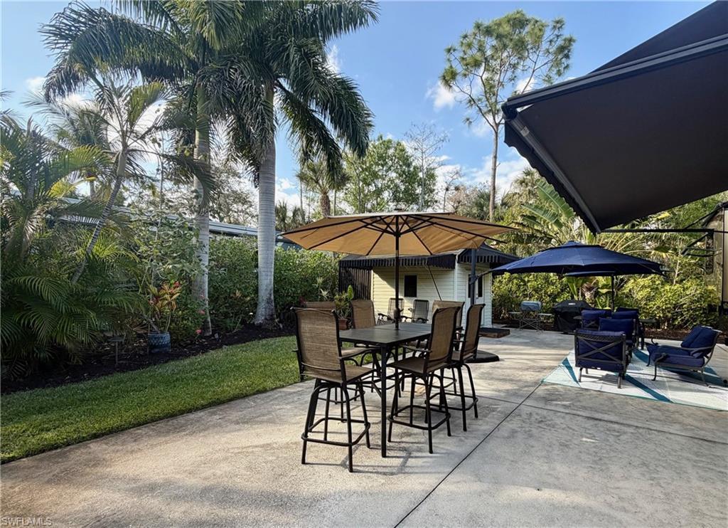 Image 2: View of patio featuring outdoor dining space and a grill