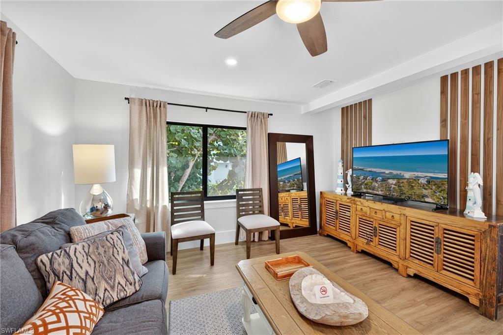 Image 3: Living area featuring light wood-style floors, ceiling fan, and recessed lighting