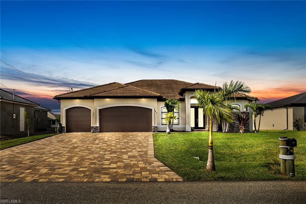Image 3: View of front of property featuring a 3 car garage and a well maintained lawn