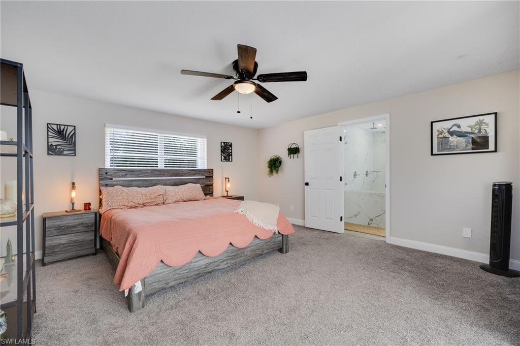 Image 4: Bedroom featuring carpet, ceiling fan, and connected bathroom