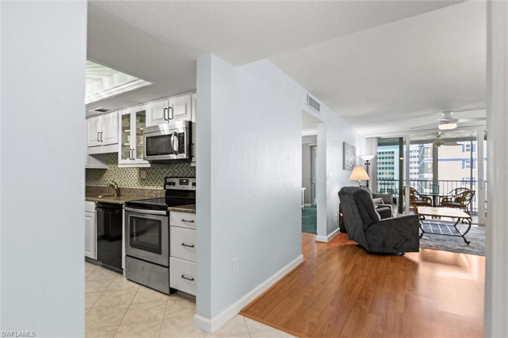 Image 2: Kitchen with stainless steel appliances, white cabinets, dark stone counters, a ceiling fan, and open floor plan