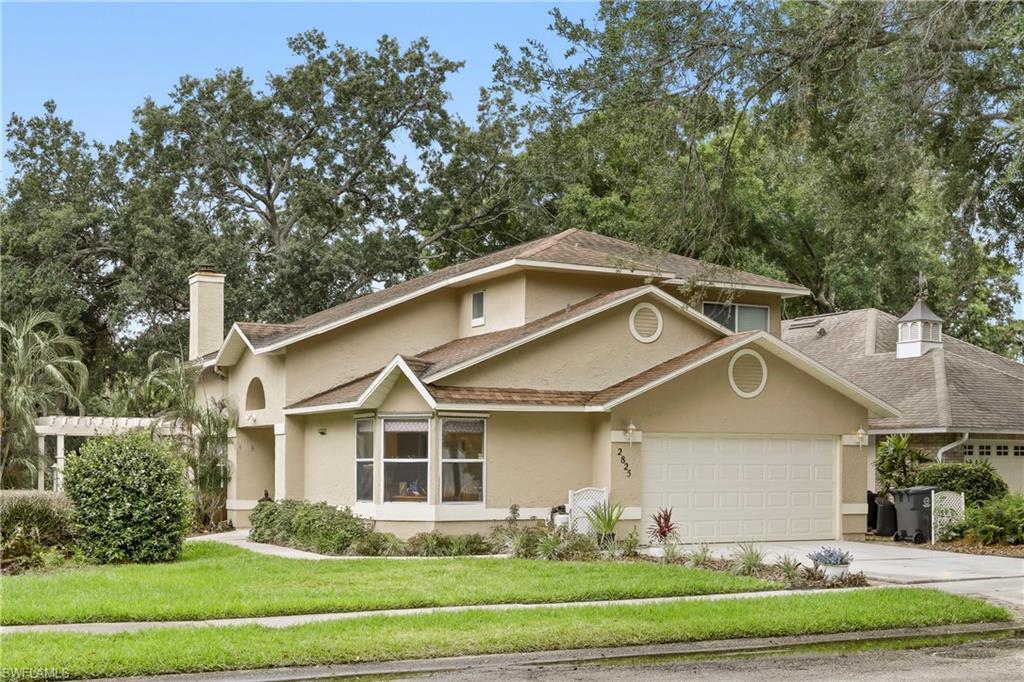 Image 2: Stucco-clad residence featuring multiple gables and a two-car garage