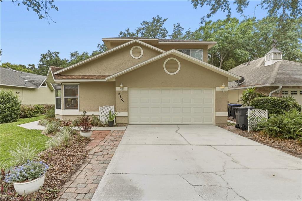Image 3: Stucco exterior featuring a two-car garage, bay window, and a brick paver walkway