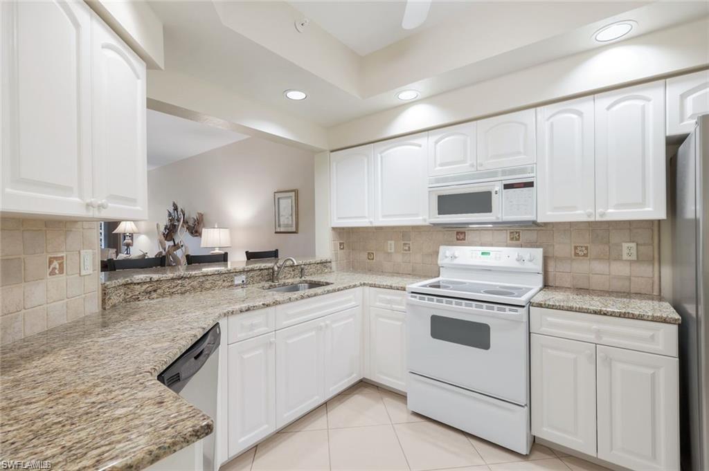 Image 4: Kitchen with appliances with stainless steel finishes, white cabinetry, decorative backsplash, and recessed lighting