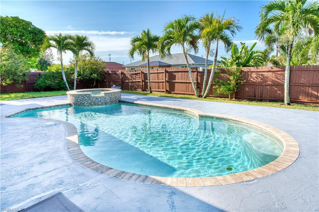 Image 2: View of swimming pool with a fenced backyard, a pool with connected hot tub, and a patio
