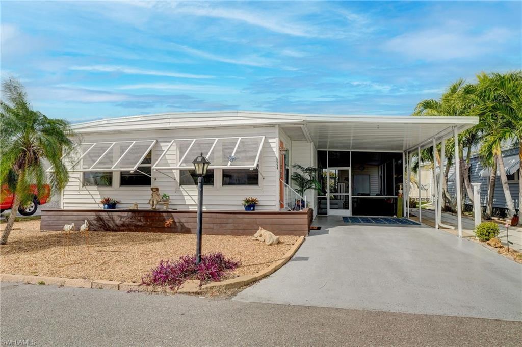 Image 1: Manufactured / mobile home with an attached carport, a sunroom, and driveway