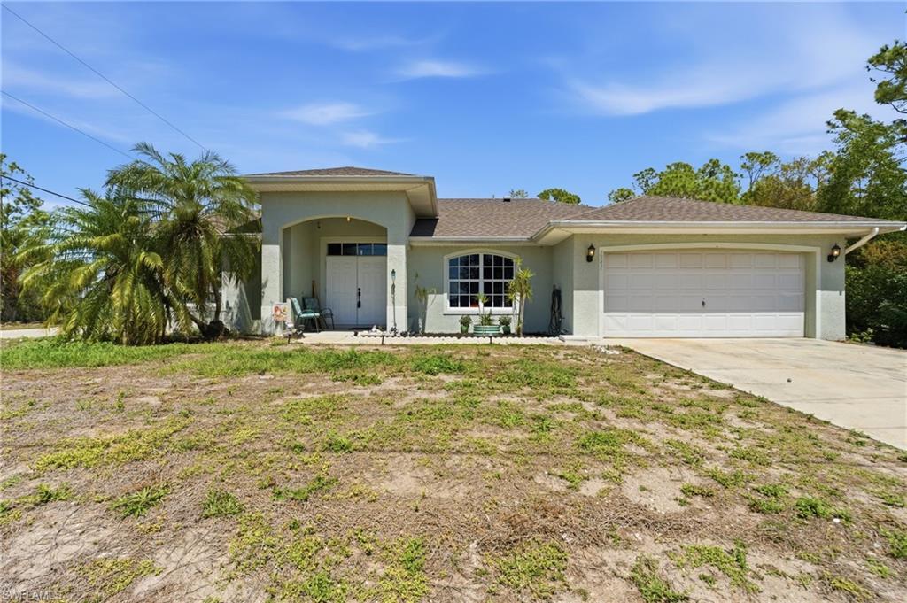 Image 1: View of front of home featuring a garage, stucco siding, concrete driveway, and roof with shingles
