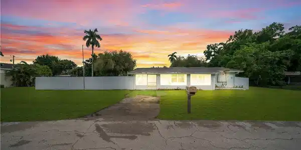 Image 2: Single-story residence with a white exterior, white fencing, and a spacious green lawn