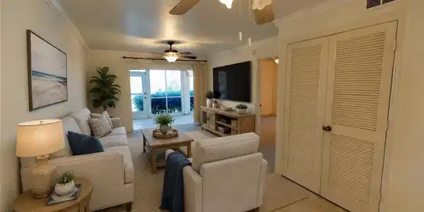 Image 2: Spacious living area featuring neutral wall tones and crown molding
