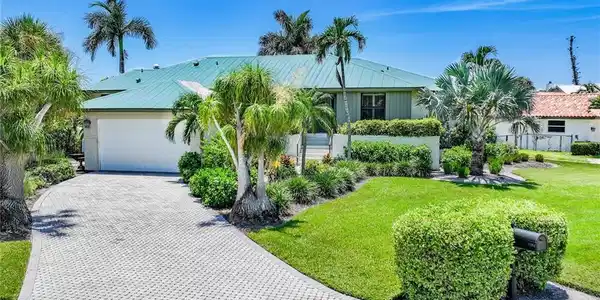 Image 3: View of front facade featuring decorative driveway and a garage