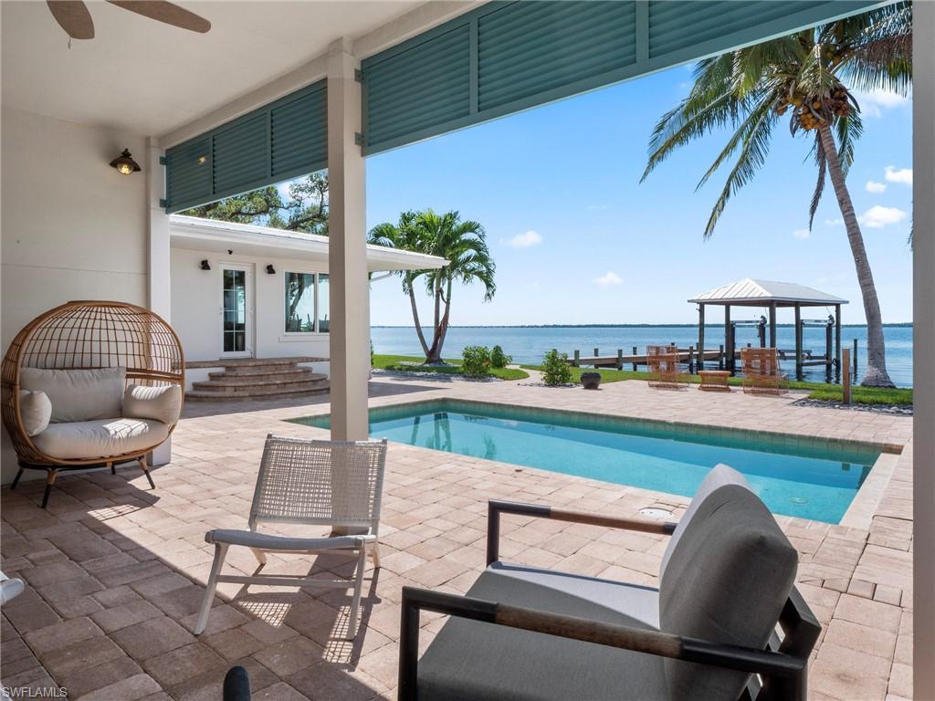 Image 4: Outdoor pool with a water view, a gazebo, and a patio area