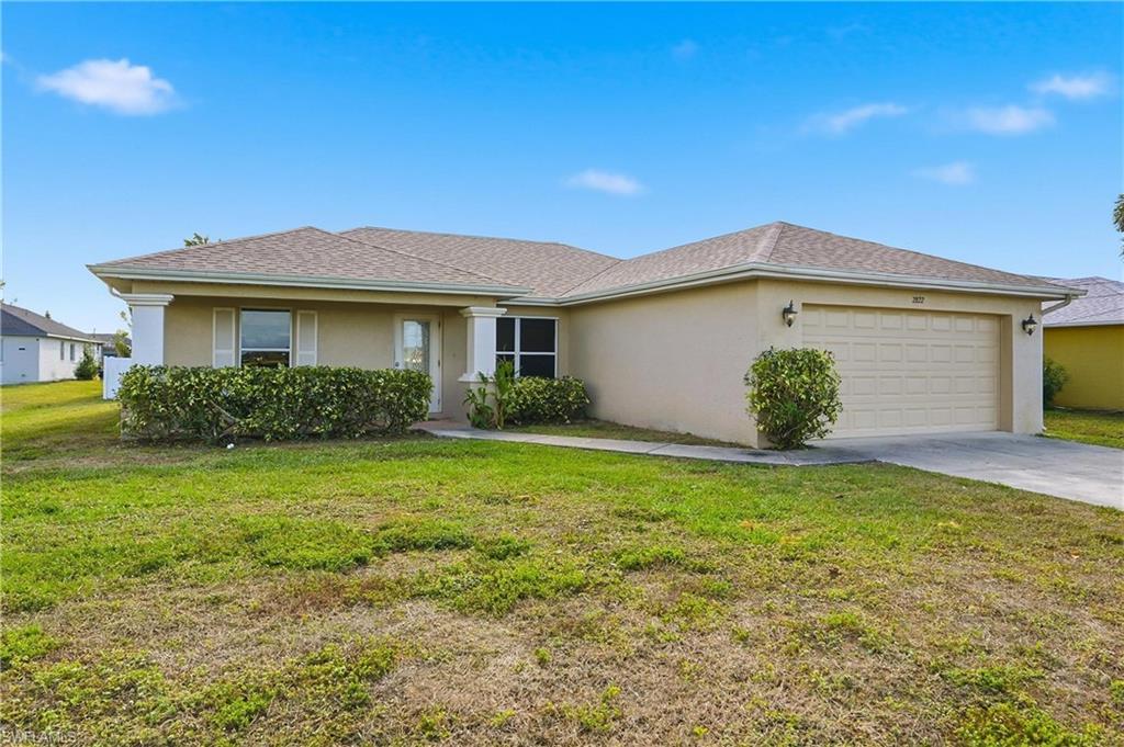 Image 2: Ranch-style home with stucco siding, a front yard, concrete driveway, and a garage