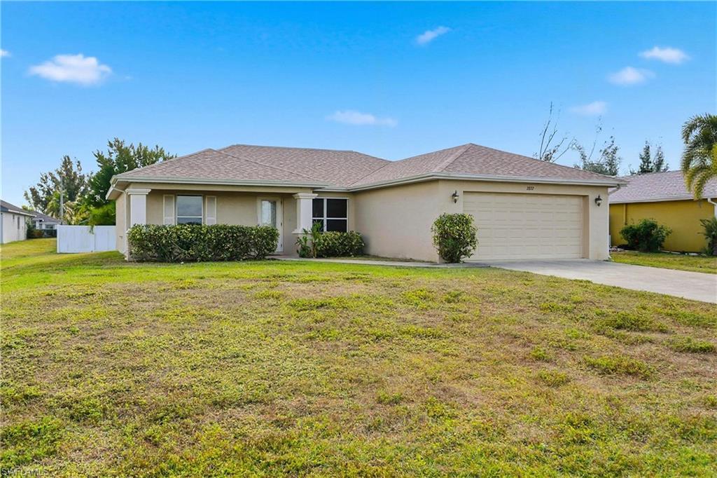 Image 3: Ranch-style house with stucco siding, concrete driveway, and a garage