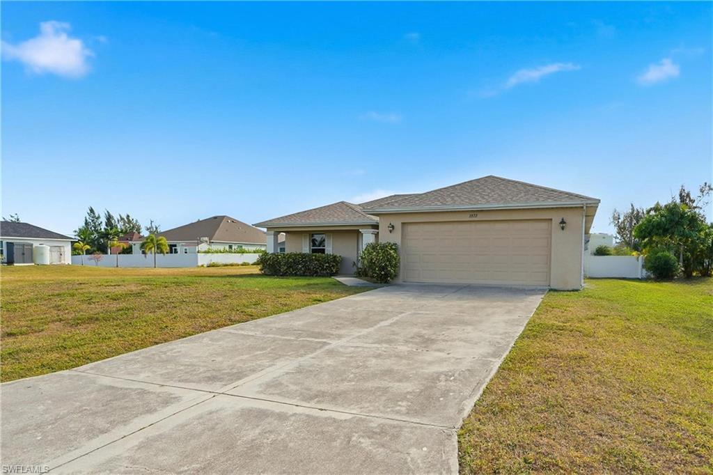 Image 4: Single story home with stucco siding, driveway, and a garage