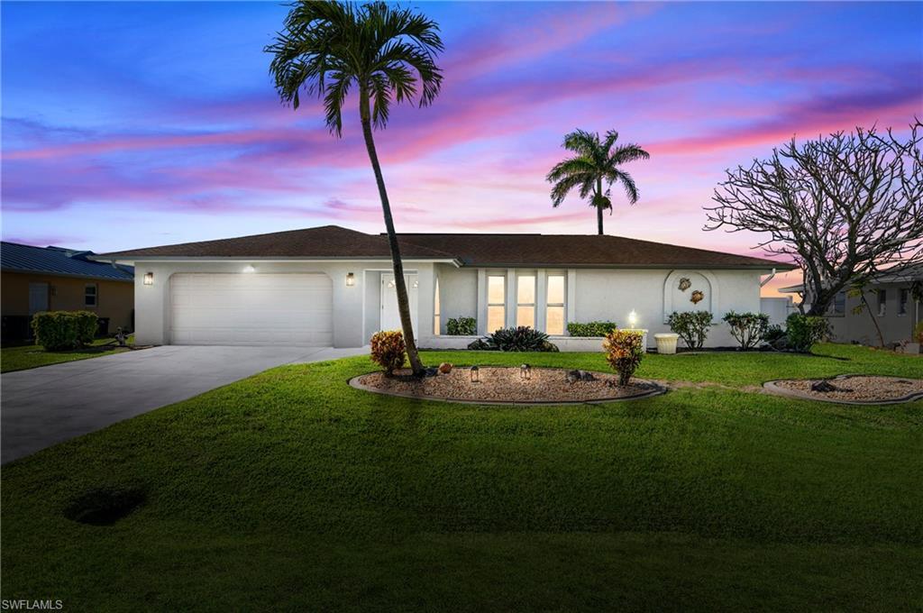 Image 1: Ranch-style home with stucco siding, driveway, a front lawn, and an attached garage