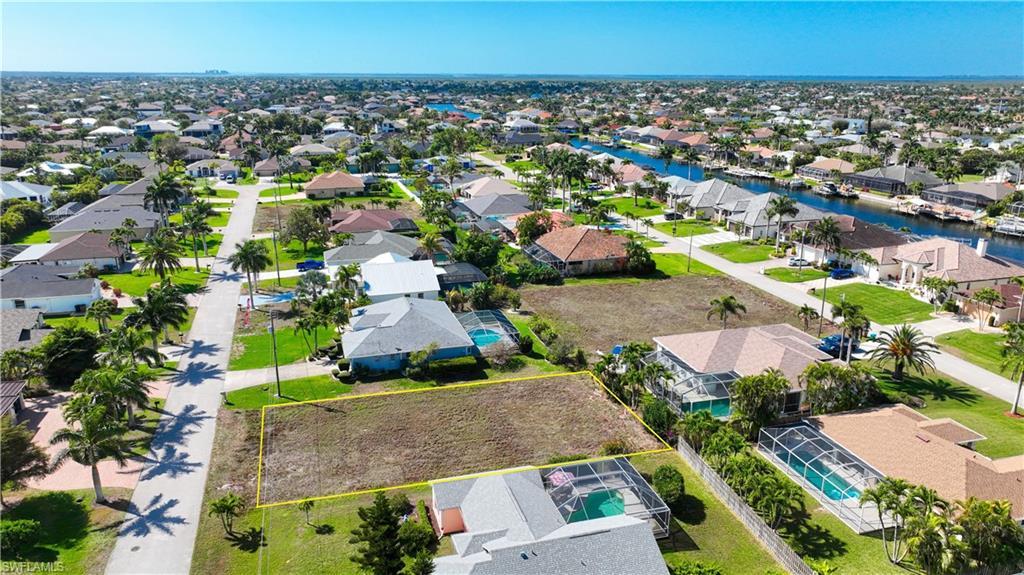 Image 2: Aerial view of residential area with property parcel outlined and a nearby body of water