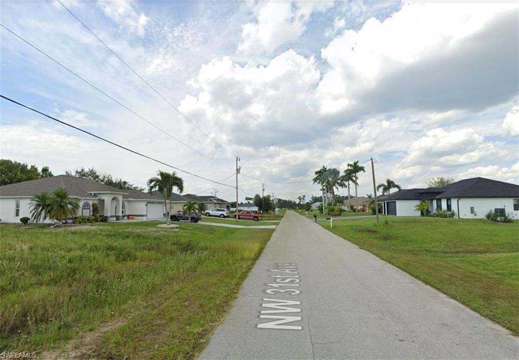 Image 3: View of asphalt road featuring a residential view