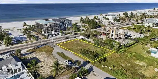 Image 4: Aerial overview of property's location with property parcel outlined and unending shoreline - Virtually Edited Image