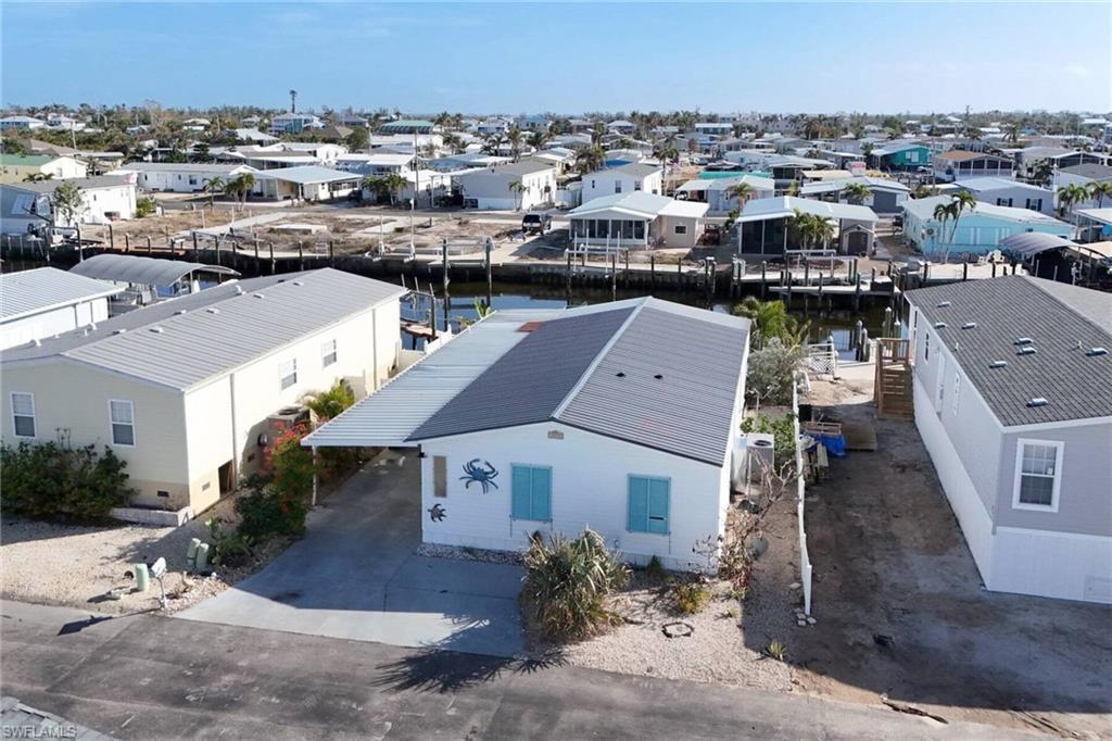 Image 3: Aerial view of residential area featuring a nearby body of water