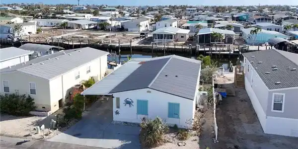 Image 3: Aerial view of residential area featuring a nearby body of water
