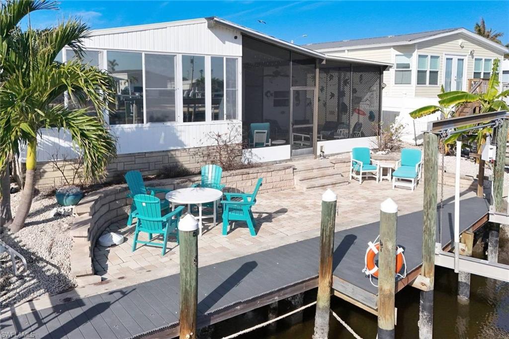 Image 4: Rear view of property featuring outdoor dining space, a patio, and a sunroom