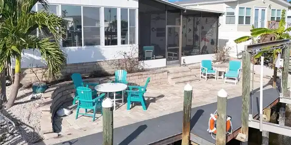 Image 4: Rear view of property featuring outdoor dining space, a patio, and a sunroom