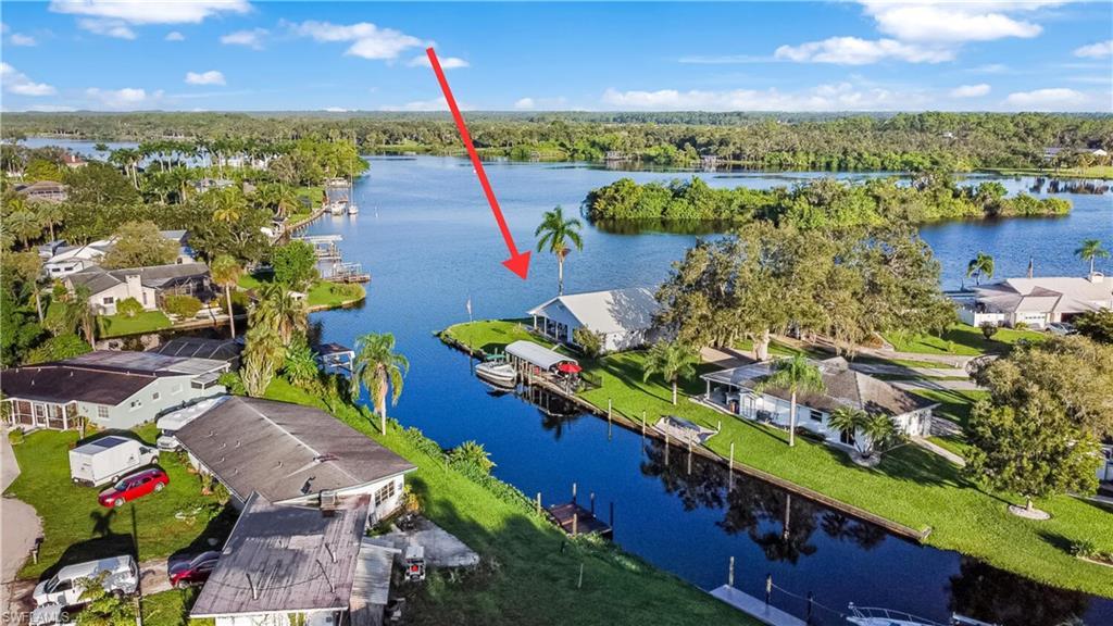Image 1: Aerial view of home on the river and wide canal at side of home.  Oversized 1/3 acres lot and end of cul-de-sac.