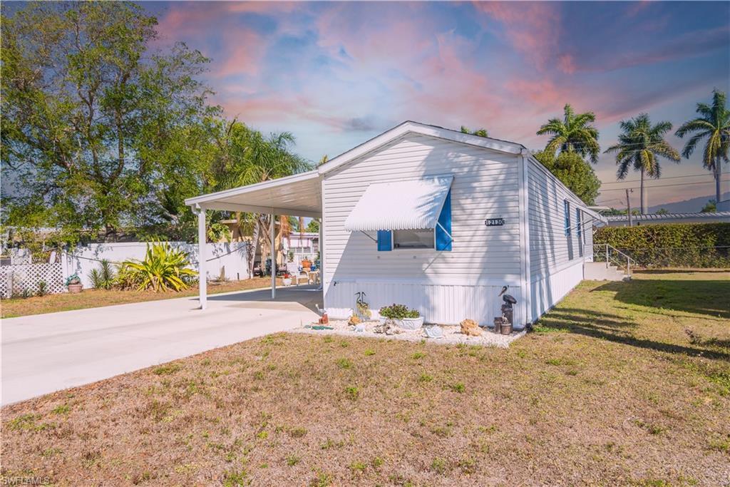 Image 1: View of side of home featuring a carport and driveway