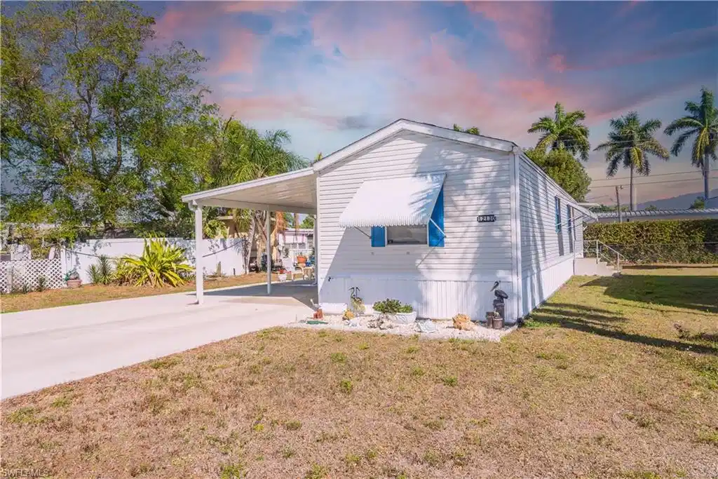 Image 1: View of side of home featuring a carport and driveway