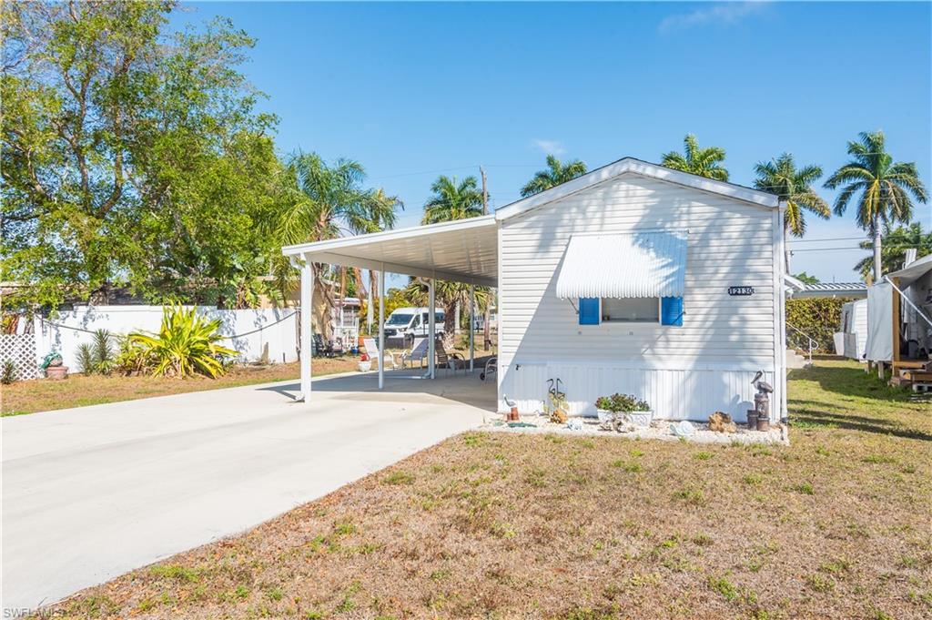 Image 3: View of home's exterior featuring an attached carport, concrete driveway, and a lawn