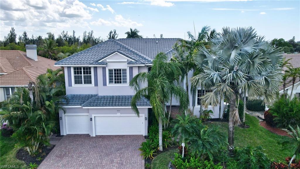 Image 1: View of front of house featuring a tile roof, an attached garage, and stucco siding
