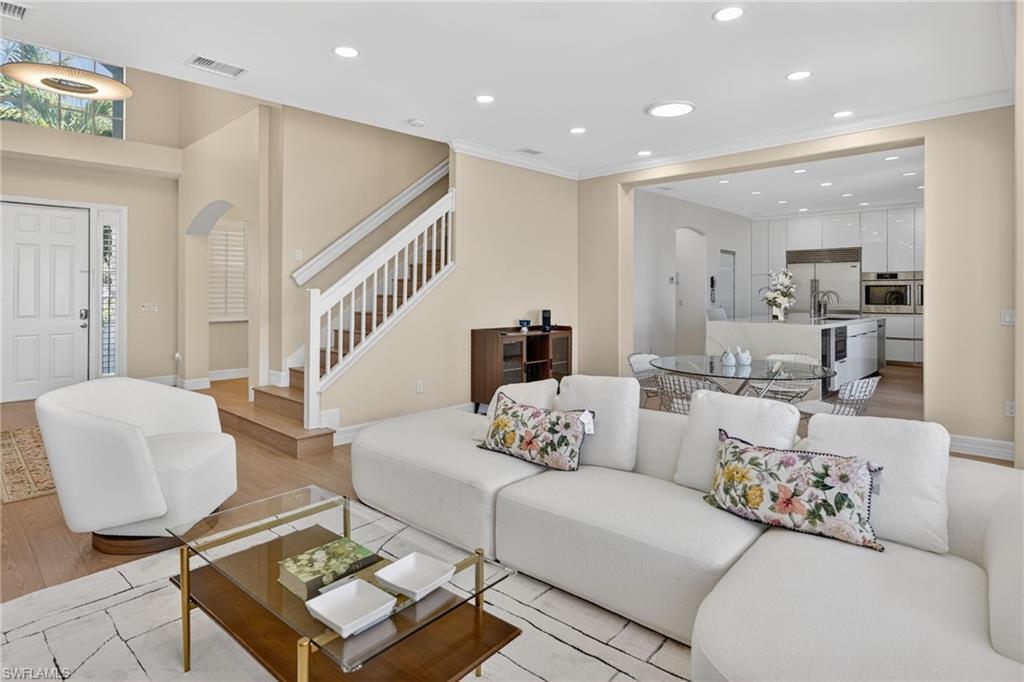 Image 4: Living room featuring arched walkways, recessed lighting, light wood-style flooring, and ornamental molding