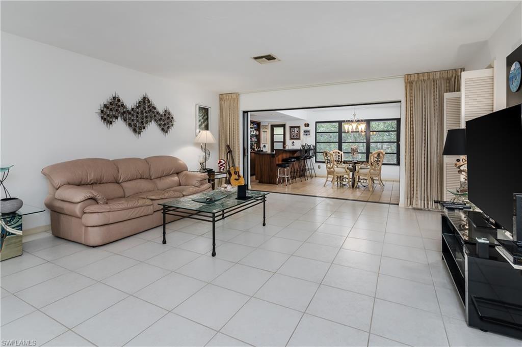 Image 4: Living room with hanging lights and light tile patterned floors