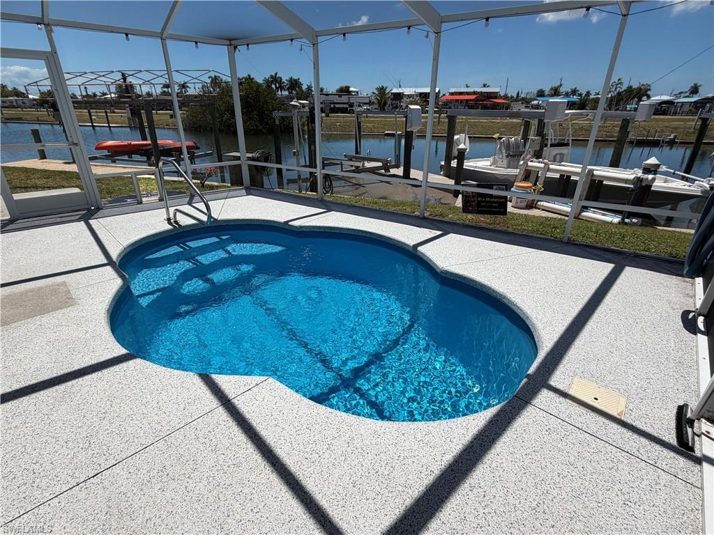 Image 3: The property features a screened-in pool with a unique shape, offering a private outdoor living space