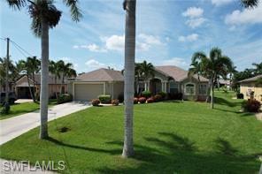 Image 3: View of front of home featuring a front yard, driveway, and a garage