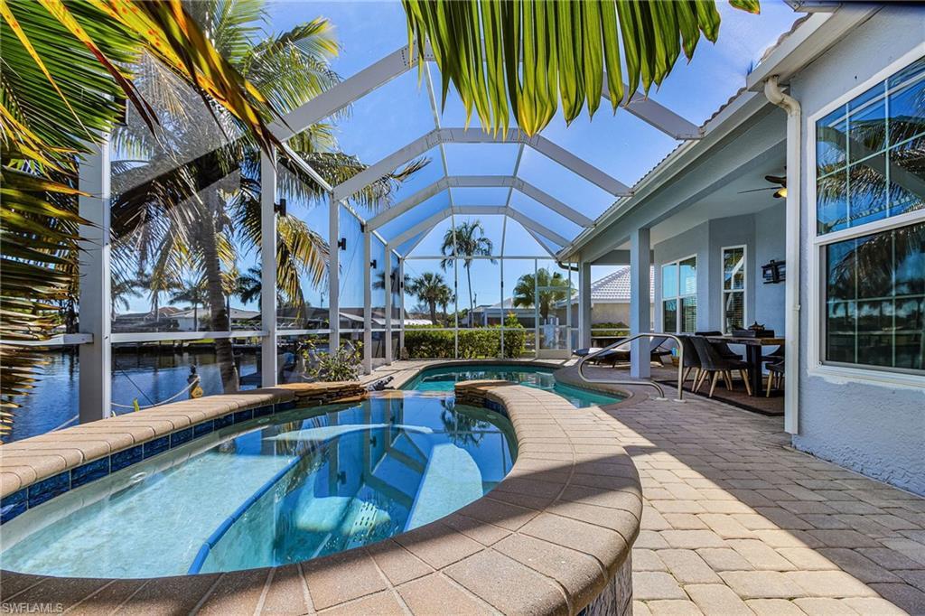 Image 3: This property features a screened-in lanai with a swimming pool and an integrated spa