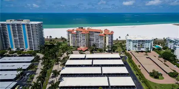 Image 2: Expansive waterfront property featuring  covered parking structures, and a wide sandy beach