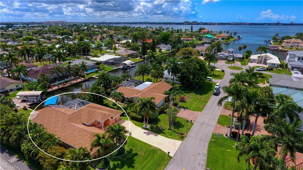 Image 1: Aerial view of residential area featuring a nearby body of water